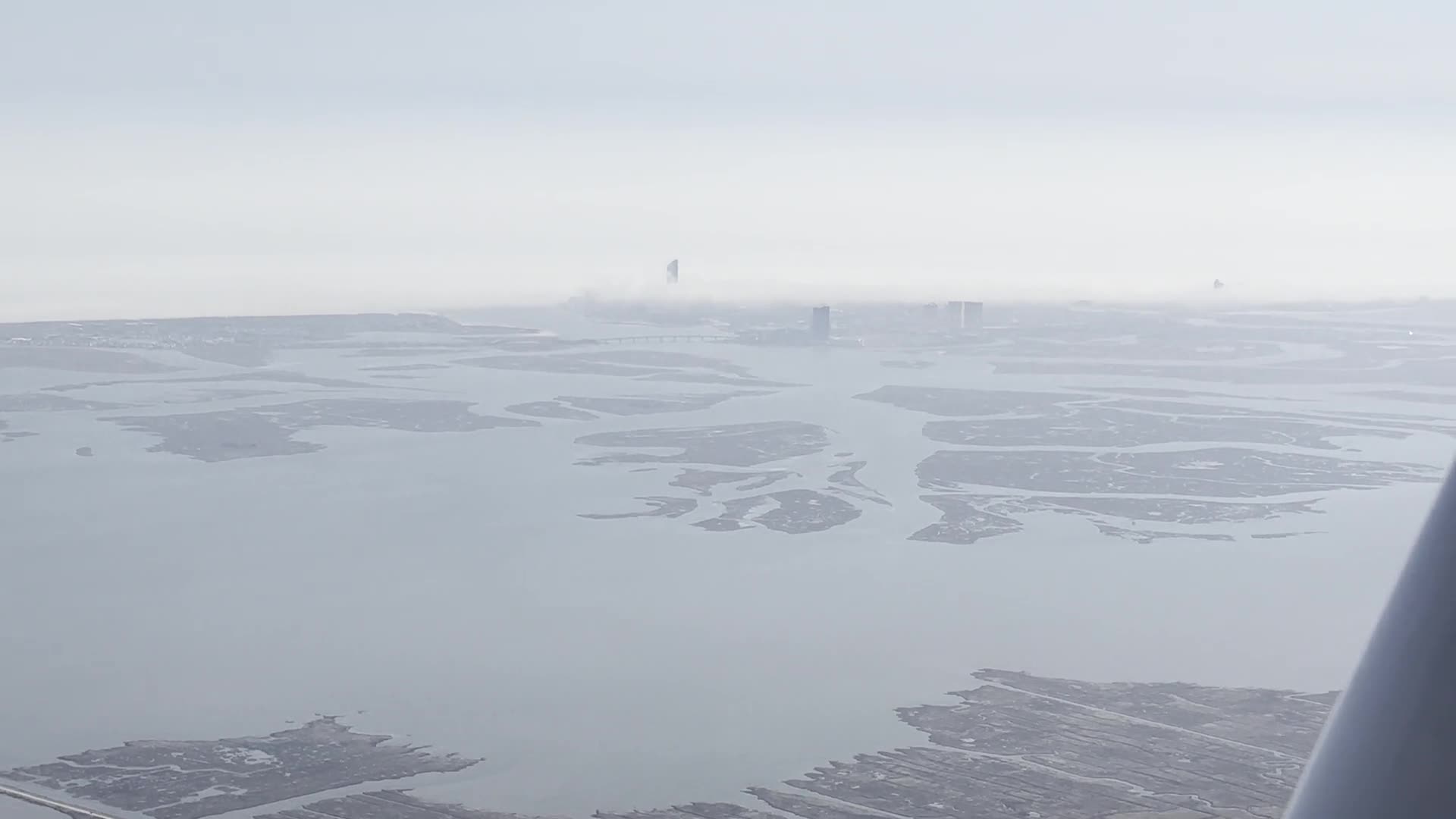 The New Jersey shore and the Atlantic City skyline seen from a training aircraft beneath a low cloud layer.
