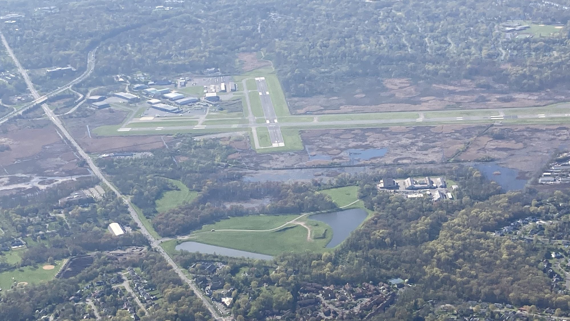 Towered airport with crossing runways seen from the traffic pattern.