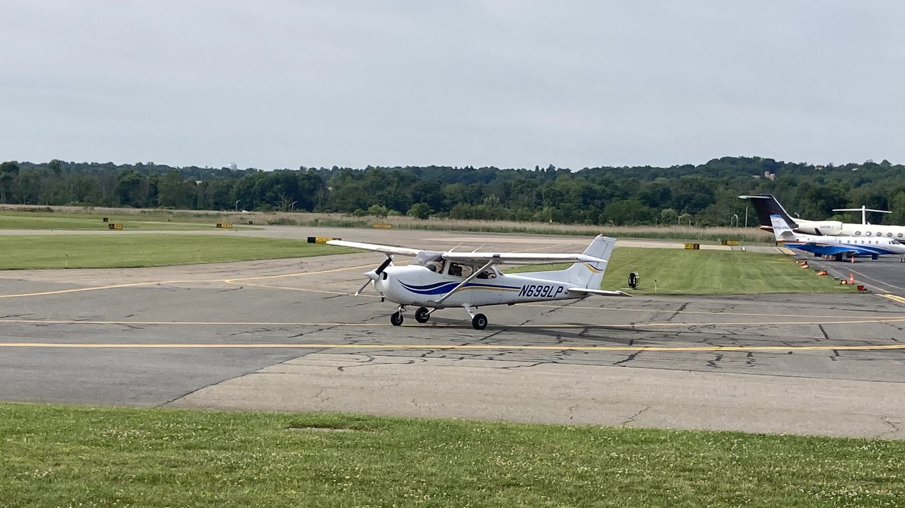 Cessna 172 taxiing on the ramp at a general aviation airport.
